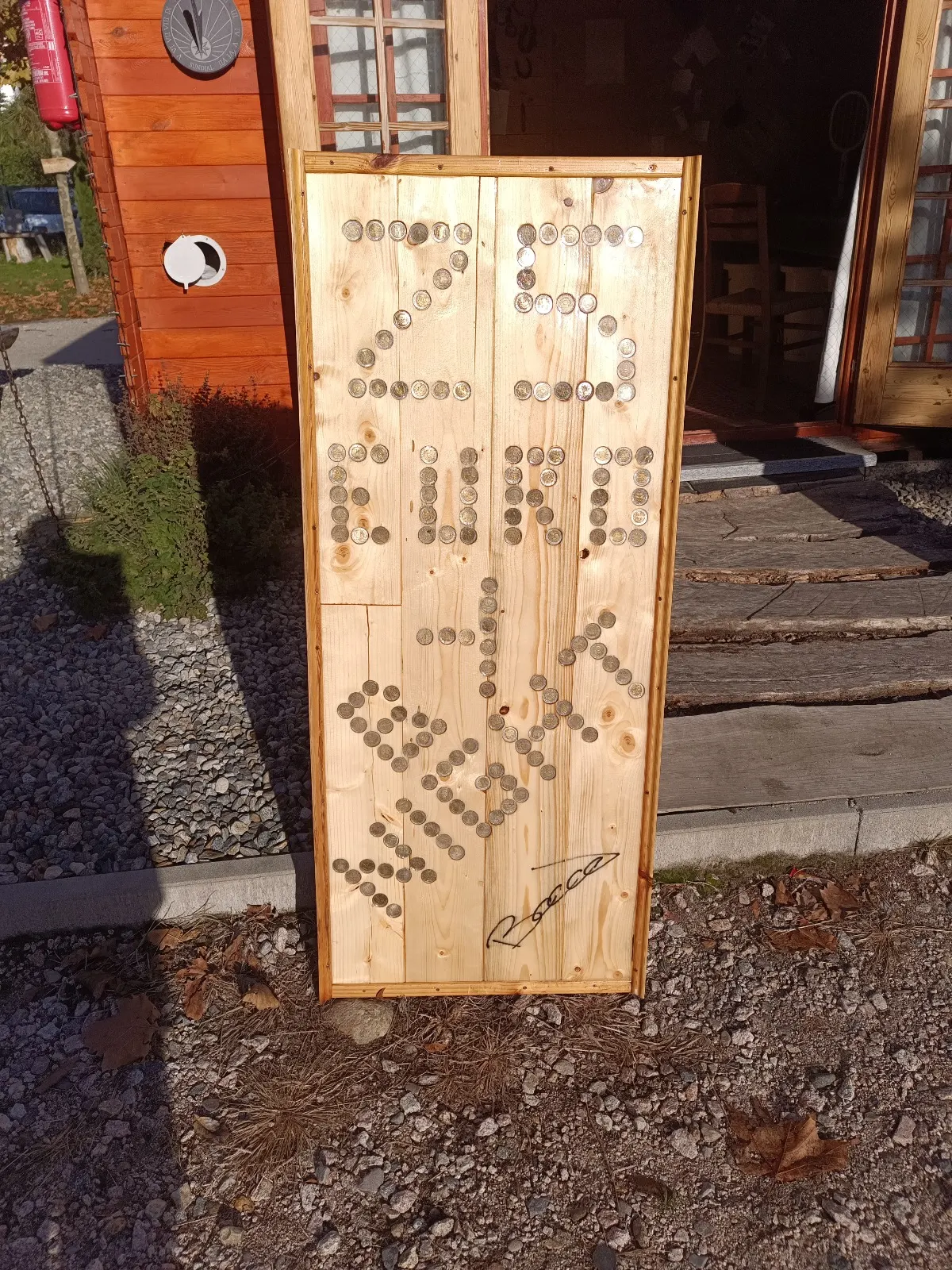 The wooden board with the price of 25 euro a night laid out in coins, signed by Bacco
