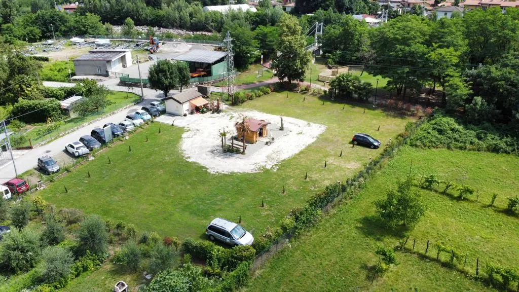 Luftaufnahme des Parkplatzes, mit dem Holzhäuschen in der Mitte der Kiesfläche