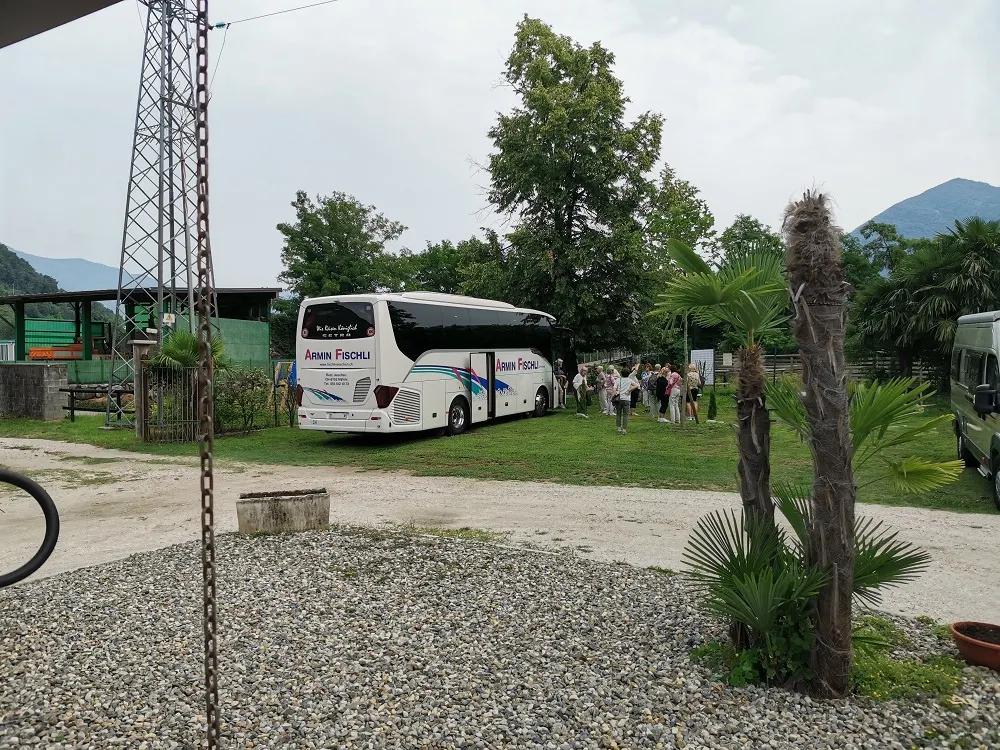 Ein Reisebus auf der Wiese, die Fahrgäste sind gerade ausgestiegen
