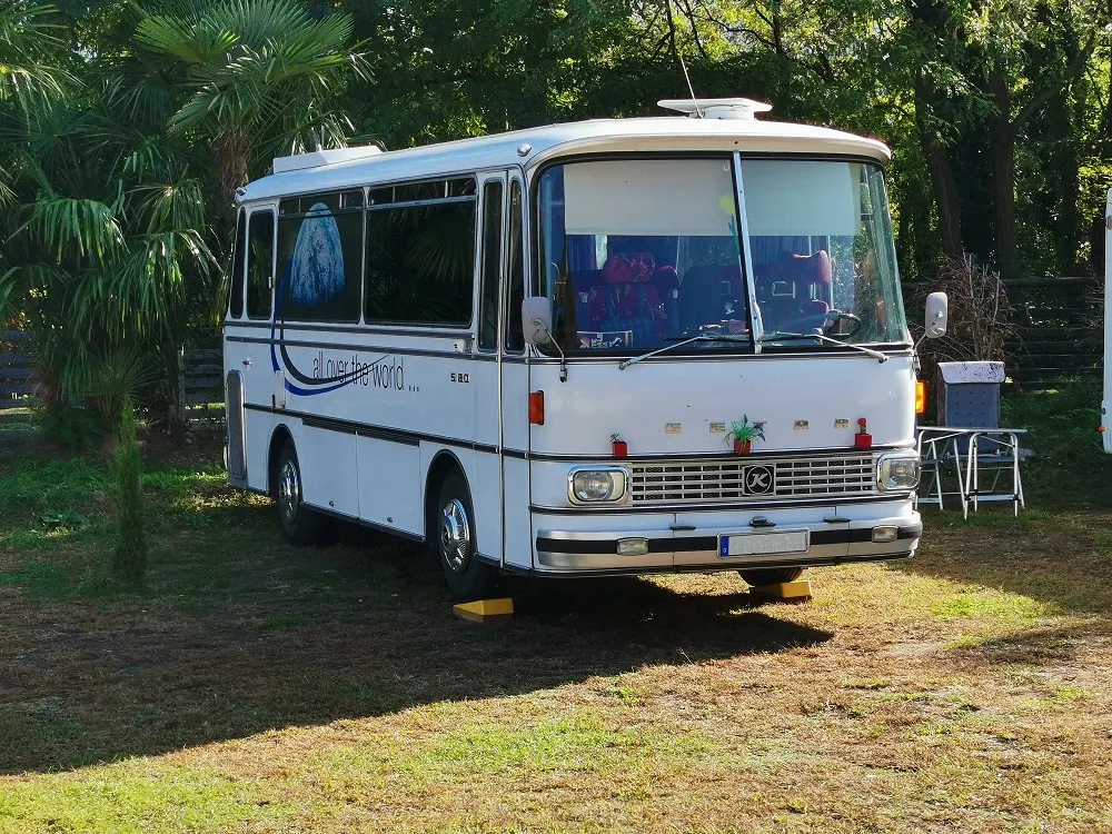 Ein zum Wohnmobil umgebauter Oldtimer-Bus auf der Wiese